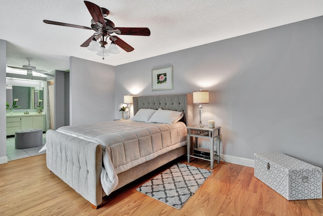 1518 15th Ln, Palm Beach Gardens, FL 33418 - bedroom featuring wood finished floors, ensuite bathroom, a textured ceiling, and a ceiling fan