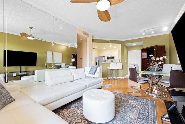 1801 N Flagler Dr Unit 931, West Palm Beach, FL 33407 - living area featuring a ceiling fan, ornamental molding, a textured ceiling, and light wood finished floors