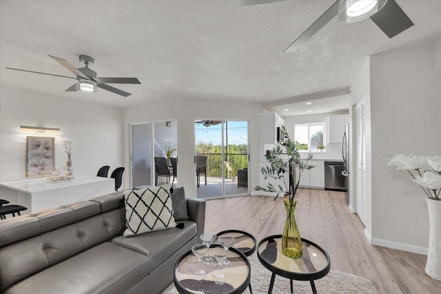 275 Palm Ave Unit B304, Jupiter, FL 33477 - living area with ceiling fan, a textured ceiling, light wood finished floors, and baseboards