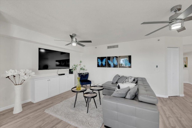 275 Palm Ave Unit B304, Jupiter, FL 33477 - living area featuring a ceiling fan, light wood-style flooring, baseboards, and a textured ceiling