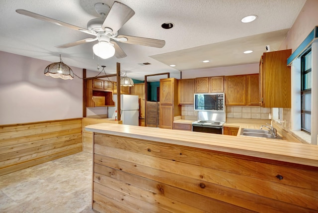 13705 Persimmon Blvd, The Acreage, FL 33411 - kitchen featuring freestanding refrigerator, a sink, electric range, light countertops, and a peninsula