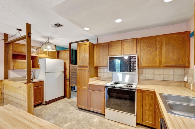 13705 Persimmon Blvd, The Acreage, FL 33411 - kitchen featuring black microwave, range with electric cooktop, freestanding refrigerator, backsplash, and light countertops