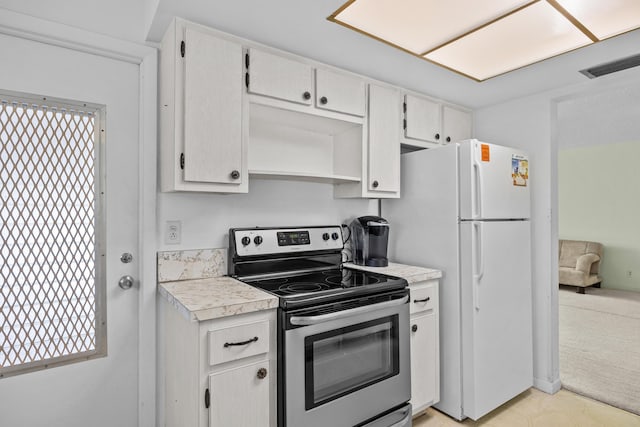 kitchen with stainless steel range with electric cooktop, freestanding refrigerator, light countertops, white cabinetry, and plenty of natural light