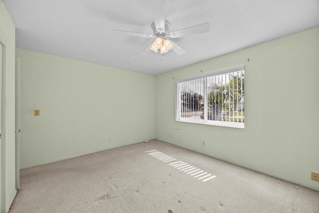 unfurnished room with carpet flooring and a ceiling fan