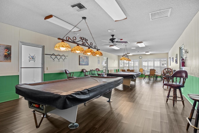 playroom with billiards, a textured ceiling, a ceiling fan, wood finished floors, and a decorative wall