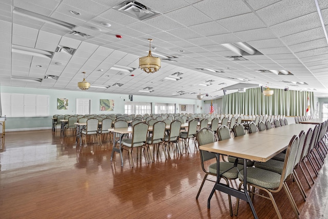 dining area featuring wood finished floors and a paneled ceiling