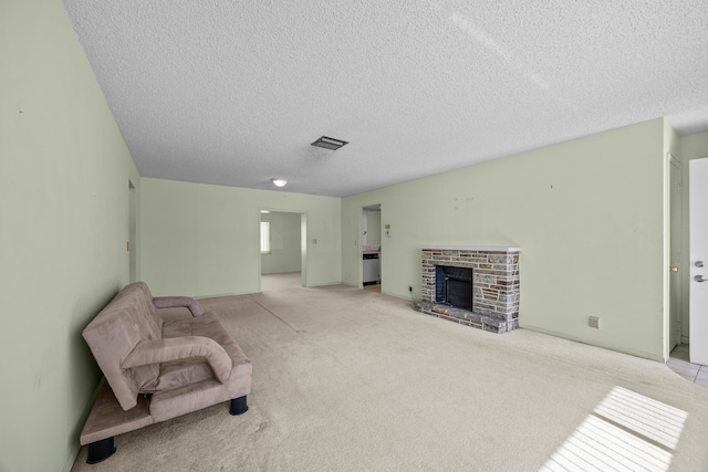 unfurnished room featuring a textured ceiling, a brick fireplace, and carpet