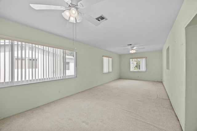 spare room with a ceiling fan and carpet flooring