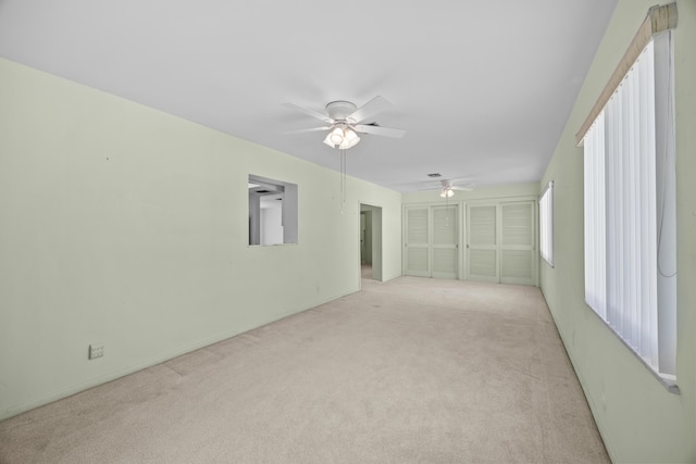 empty room with light colored carpet and ceiling fan