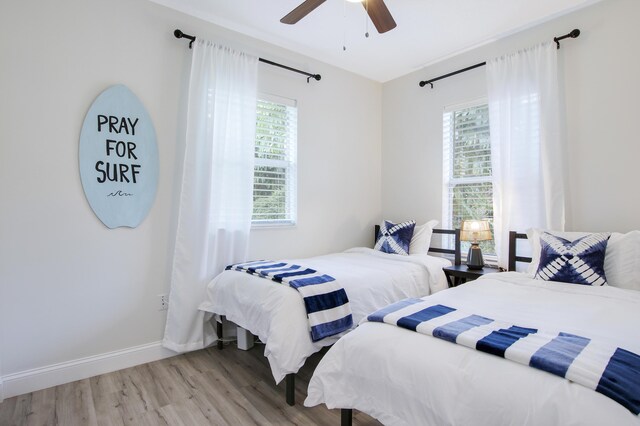 2559 Conroy Dr, North Palm Beach, FL 33403 - bedroom featuring multiple windows, light wood-type flooring, baseboards, and a ceiling fan