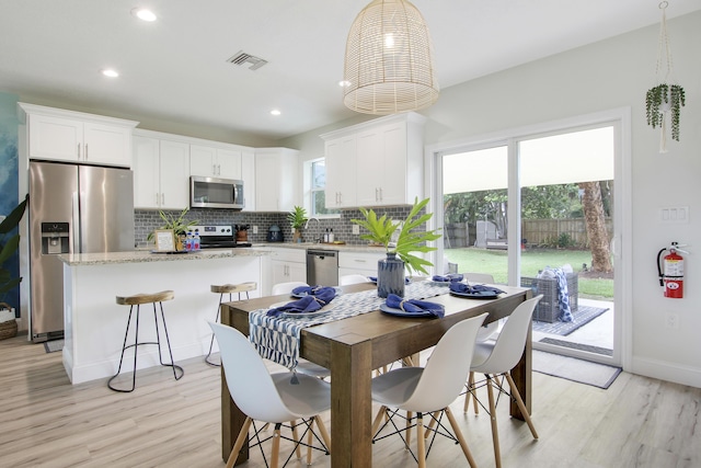 2559 Conroy Dr, North Palm Beach, FL 33403 - dining area with light wood-style flooring, recessed lighting, and baseboards