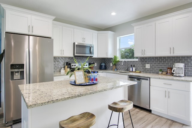 2559 Conroy Dr, North Palm Beach, FL 33403 - kitchen featuring appliances with stainless steel finishes, a sink, white cabinets, tasteful backsplash, and recessed lighting