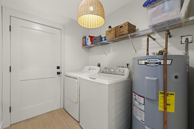 4972 S Kay St, Palm Beach Gardens, FL 33418 - laundry area featuring electric water heater, washing machine and clothes dryer, and light wood-type flooring