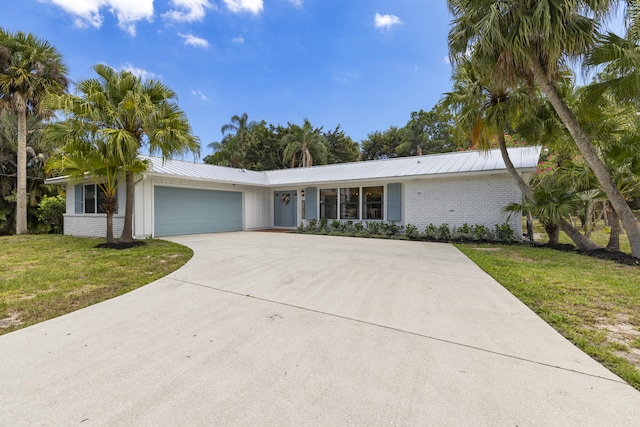 4972 S Kay St, Palm Beach Gardens, FL 33418 - view of front of property featuring a garage, brick siding, a front lawn, and driveway