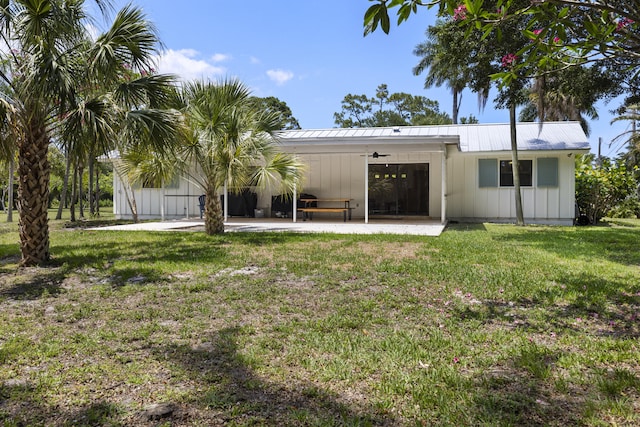 4972 S Kay St, Palm Beach Gardens, FL 33418 - rear view of house with board and batten siding, a patio area, a ceiling fan, and a yard