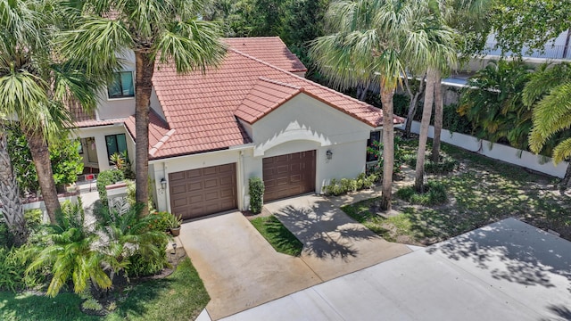 703 Sea Oats Dr Unit A-5, Juno Beach, FL 33408 - view of front facade with a tiled roof, concrete driveway, an attached garage, and stucco siding