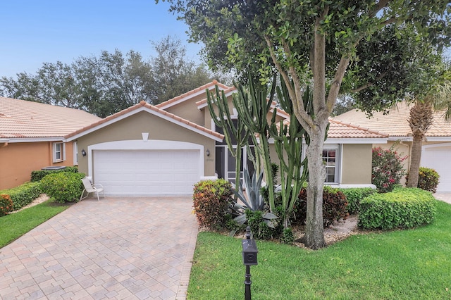 12092 Aprilia Dr, Boynton Beach, FL 33437 - view of front facade with a tile roof, stucco siding, a garage, and decorative driveway