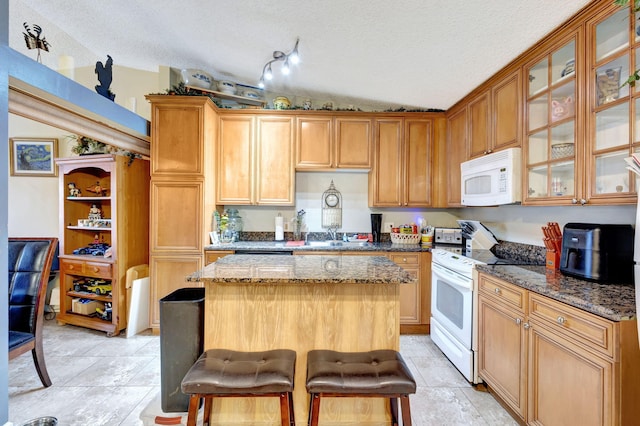 4296 Woodstock Dr Unit A, West Palm Beach, FL 33409 - kitchen with white appliances, a textured ceiling, a kitchen island, dark stone countertops, and glass insert cabinets