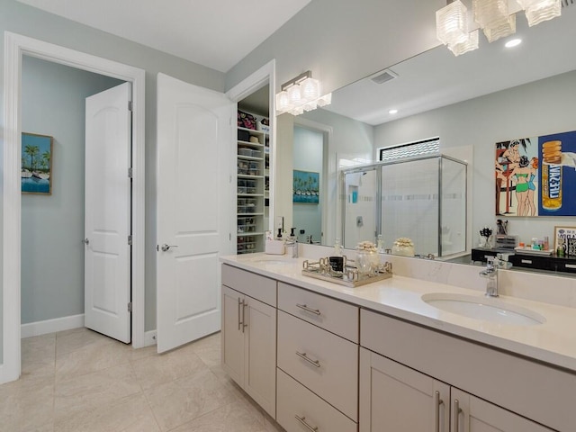 5082 Monroe Cir, Vero Beach, FL 32967 - full bathroom with a shower stall, double vanity, a walk in closet, tile patterned floors, and baseboards