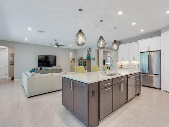 5082 Monroe Cir, Vero Beach, FL 32967 - kitchen with appliances with stainless steel finishes, a sink, white cabinets, light countertops, and tasteful backsplash