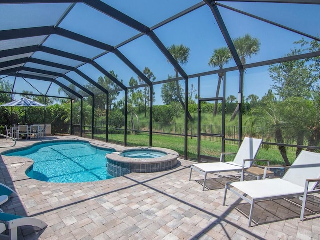 5082 Monroe Cir, Vero Beach, FL 32967 - view of swimming pool featuring a patio, glass enclosure, and a pool with connected hot tub
