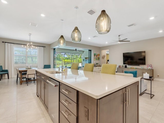 5082 Monroe Cir, Vero Beach, FL 32967 - kitchen with dishwasher, an island with sink, light tile patterned flooring, open floor plan, and light countertops
