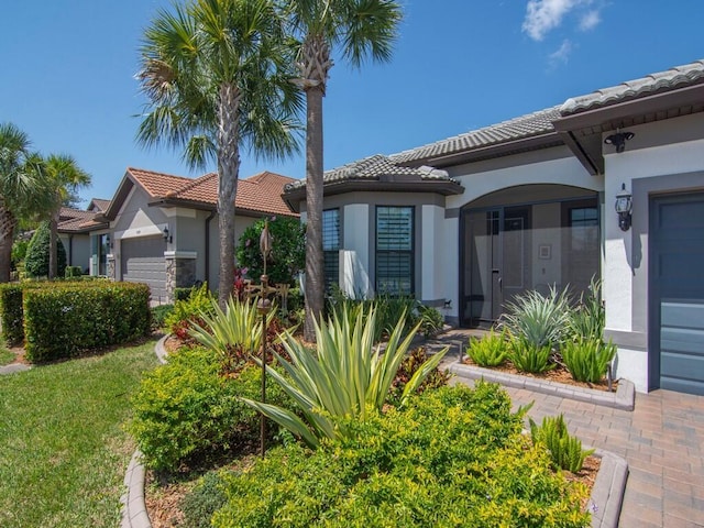 5082 Monroe Cir, Vero Beach, FL 32967 - view of front of property featuring an attached garage, a tile roof, and stucco siding