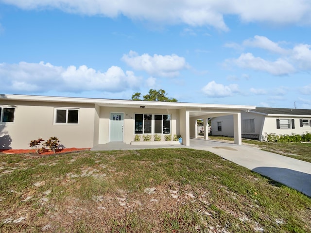 417 Philadelphia Dr, Jupiter, FL 33458 - rear view of house with stucco siding, concrete driveway, an attached carport, and a yard