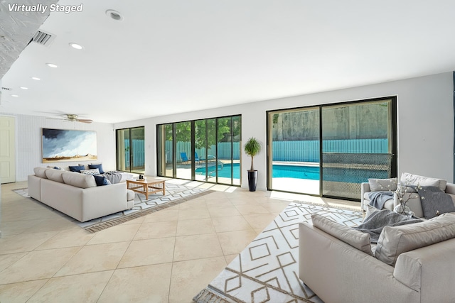 tiled living area with a ceiling fan and recessed lighting
