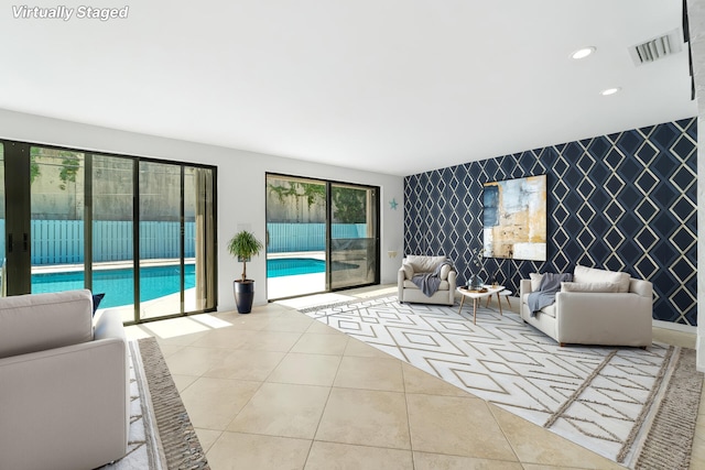 living room with an accent wall, wallpapered walls, recessed lighting, and tile patterned flooring
