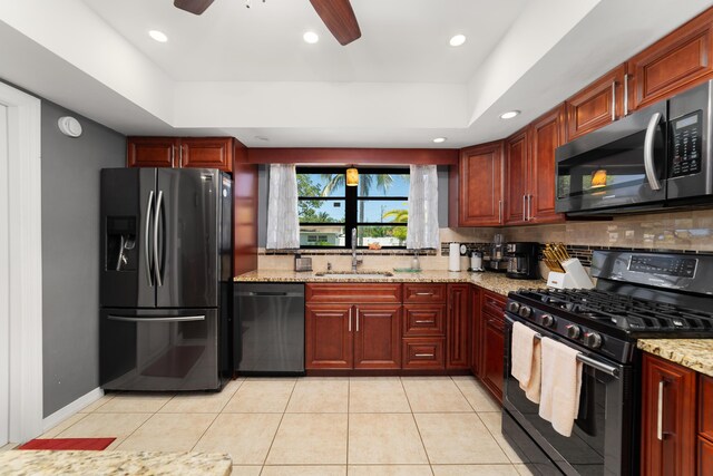 kitchen featuring black appliances, a sink, decorative backsplash, a raised ceiling, and recessed lighting