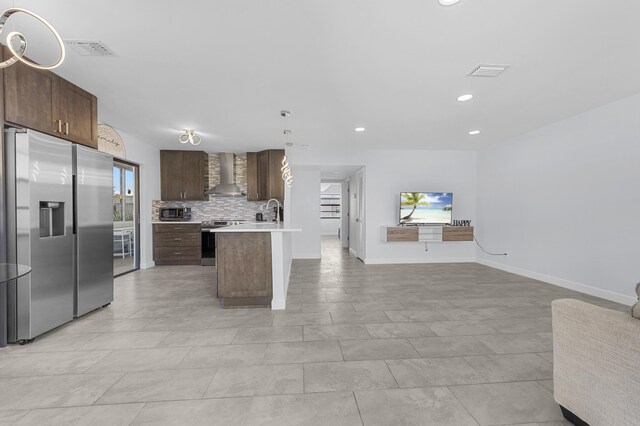 234 Capri E, Delray Beach, FL 33484 - kitchen with stainless steel appliances, wall chimney range hood, open floor plan, light countertops, and dark brown cabinetry