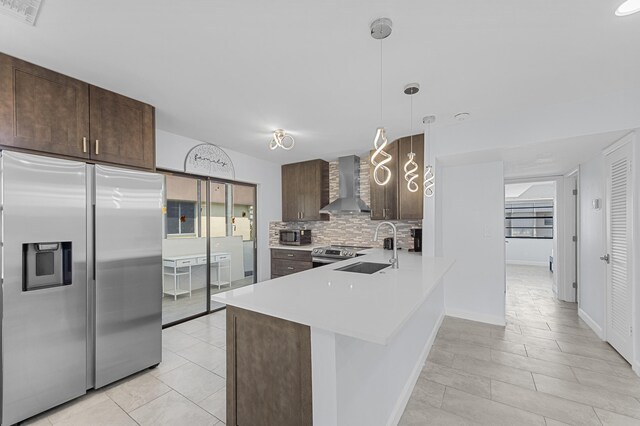 234 Capri E, Delray Beach, FL 33484 - kitchen featuring stainless steel appliances, wall chimney exhaust hood, dark brown cabinets, and tasteful backsplash