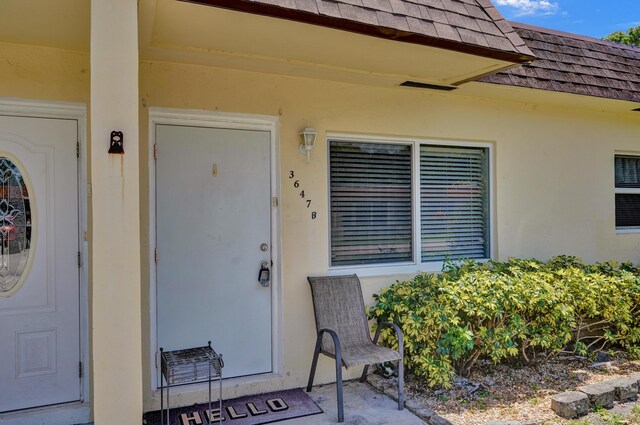 3647 SW Natura Ave Unit B, Deerfield Beach, FL 33441 - property entrance with roof with shingles, mansard roof, and stucco siding