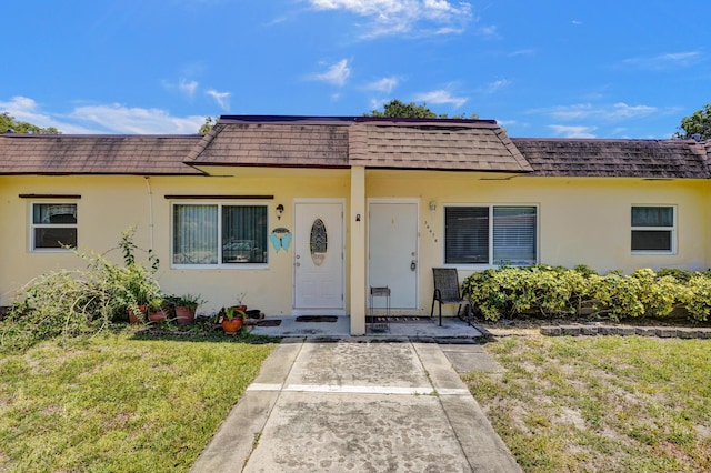 3647 SW Natura Ave Unit B, Deerfield Beach, FL 33441 - view of front facade with mansard roof, roof with shingles, and stucco siding
