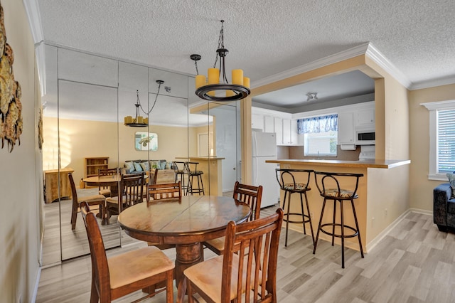 3647 SW Natura Ave Unit B, Deerfield Beach, FL 33441 - dining space featuring light wood-type flooring, ornamental molding, a textured ceiling, and baseboards