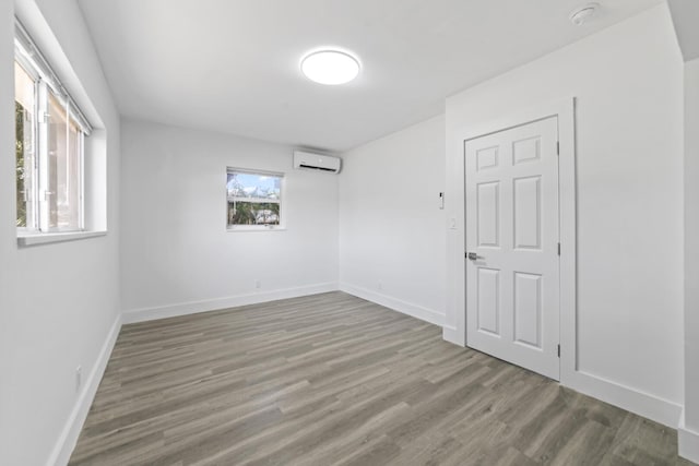 2232 SW 14th Ct, Fort Lauderdale, FL 33312 - empty room with an AC wall unit, wood finished floors, a smoke detector, and baseboards