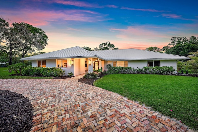 6799 Imperial Woods Rd, Jupiter, FL 33458 - view of front of property featuring stucco siding, a front yard, metal roof, a standing seam roof, and covered porch