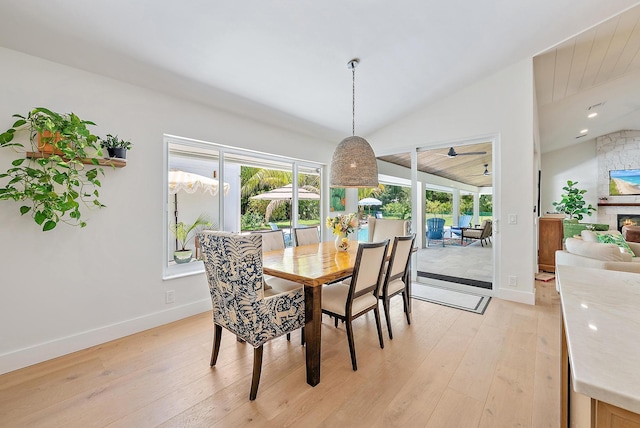 6799 Imperial Woods Rd, Jupiter, FL 33458 - dining room featuring healthy amount of natural light, lofted ceiling, light wood finished floors, baseboards, and a stone fireplace