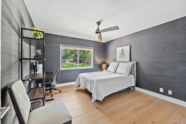 6799 Imperial Woods Rd, Jupiter, FL 33458 - bedroom with a desk, wood finished floors, baseboards, wallpapered walls, and a textured ceiling