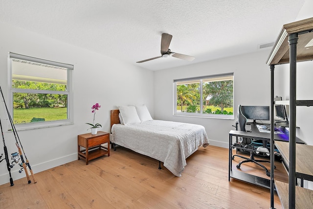 6799 Imperial Woods Rd, Jupiter, FL 33458 - bedroom with a desk, baseboards, light wood-style floors, a textured ceiling, and ceiling fan