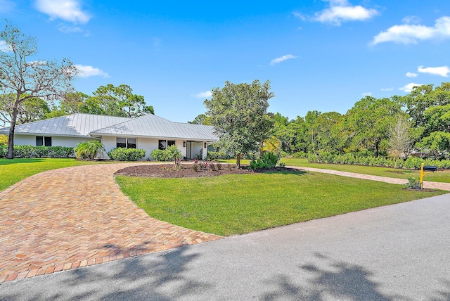 6799 Imperial Woods Rd, Jupiter, FL 33458 - single story home featuring curved driveway, a front yard, and metal roof