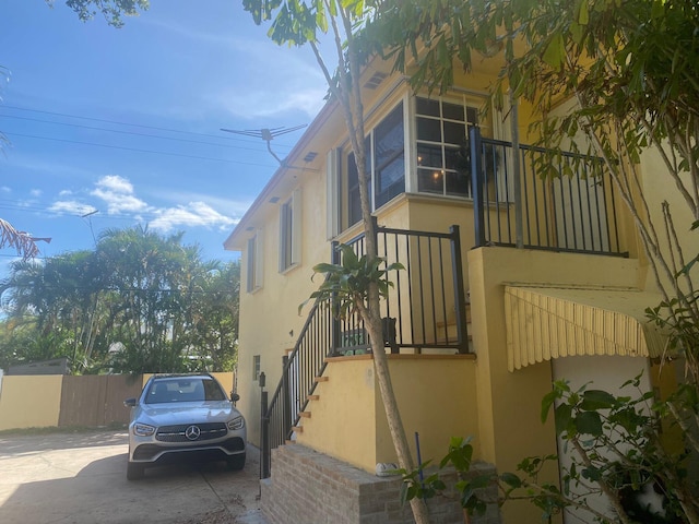 1120 S Federal Hwy, Lake Worth, FL 33460 - view of property exterior with stucco siding, stairway, and fence