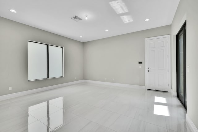 unfurnished room with recessed lighting, baseboards, and light tile patterned flooring