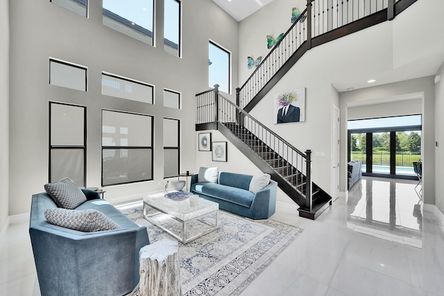 living room with a high ceiling, stairway, and baseboards
