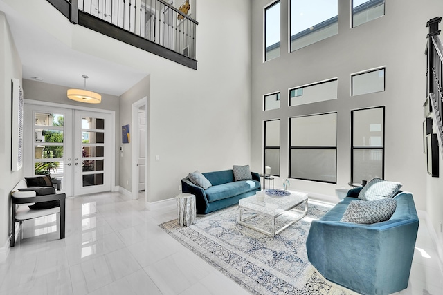 living room featuring a high ceiling, baseboards, and french doors