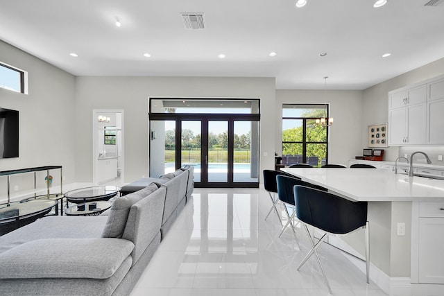 living area with recessed lighting, light tile patterned floors, french doors, and a chandelier