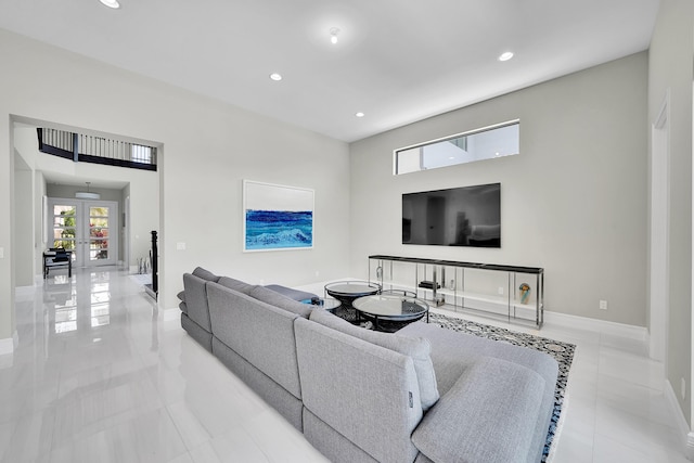 tiled living area with french doors, baseboards, recessed lighting, and a towering ceiling