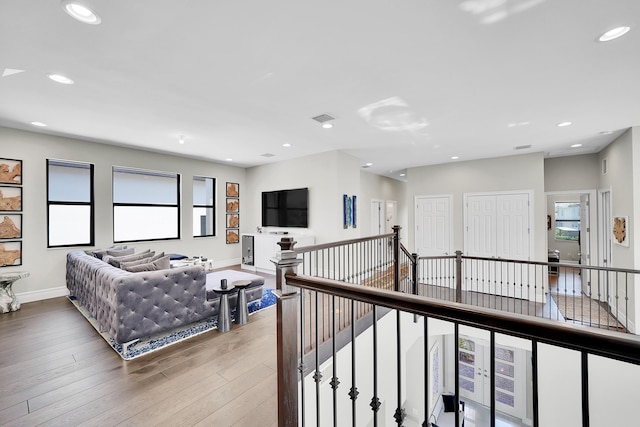 living area with wood finished floors, recessed lighting, and baseboards