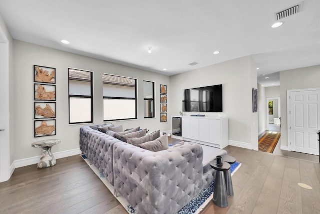 living room featuring hardwood / wood-style floors, recessed lighting, and baseboards